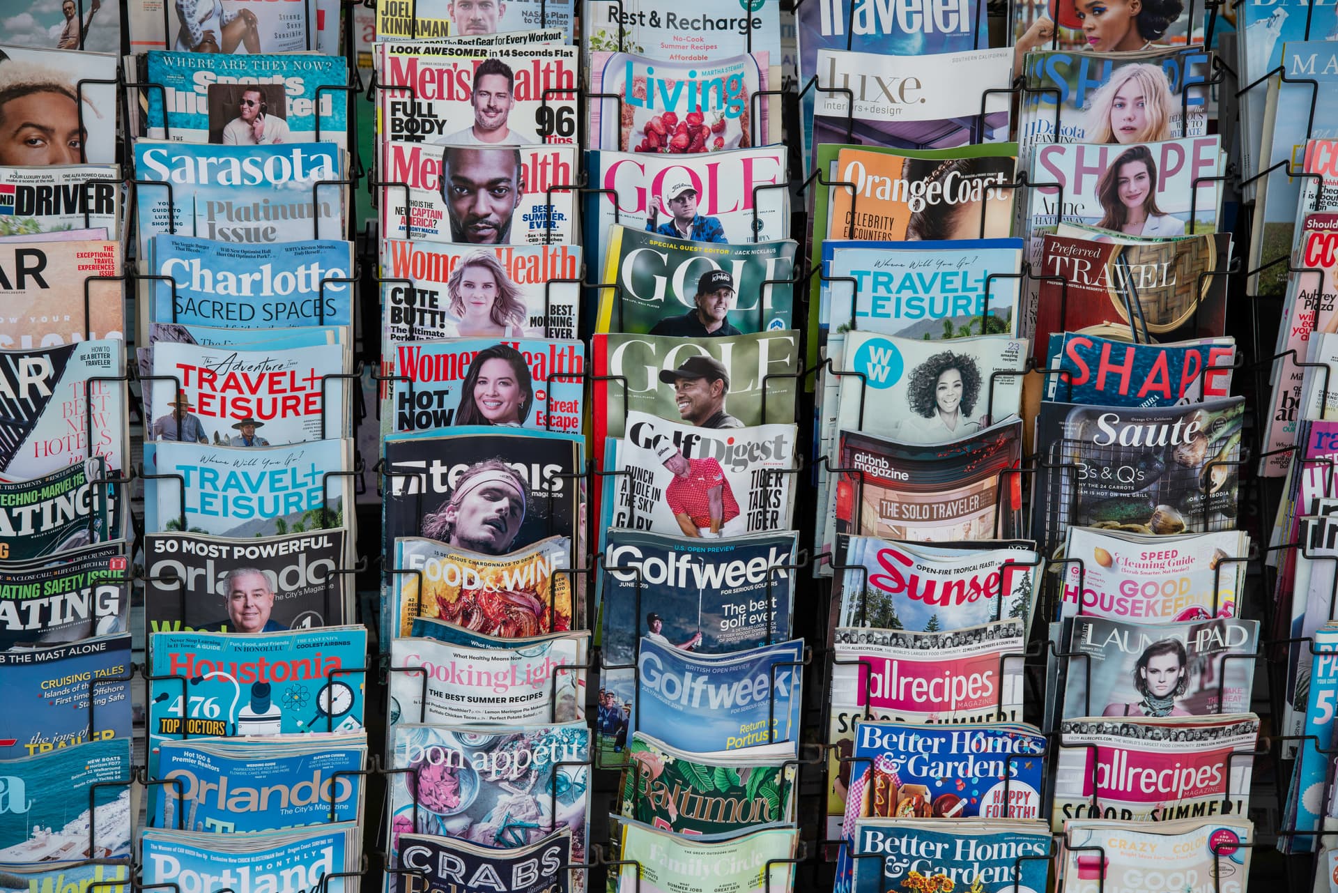 Rows of newspapers and magazines displayed at a newsstand