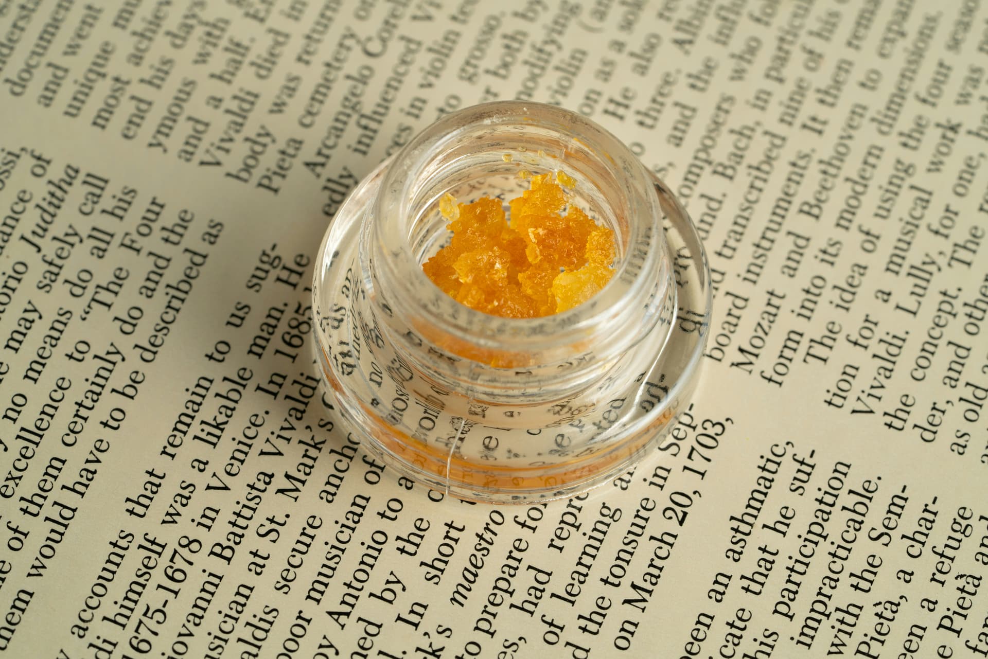 Yellow cannabis extract crystals in a small glass jar